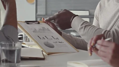 Team Collaborating on Financial Charts in a Modern Office Stock Footage 321985366