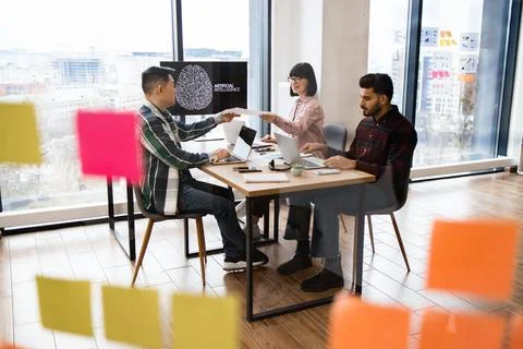Team collaborating in modern office with artificial intelligence presentation Stock Photos