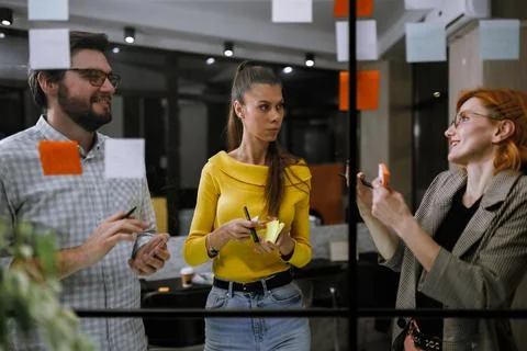 Team collaborating in a modern office brainstorming session with sticky notes on Stock Photos