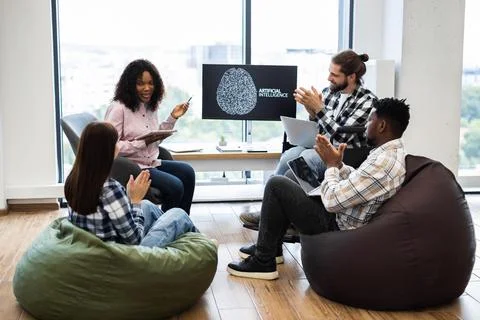 Team collaboration on artificial intelligence in casual workspace setting Stockfoto's