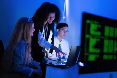 Team collaboration in a tech workspace with screens and digital data analys.. Stock Photos