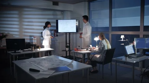 Team of Computer Engineers discussing something on a big TV screen in lab Vídeos de archivo 112918893