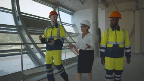 Team of construction workers discussing project details with female executive Stock Footage 137311602