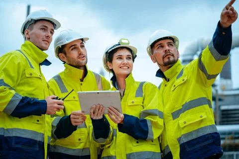 Team of construction workers discussing project details on a building site .. Stock Photos
