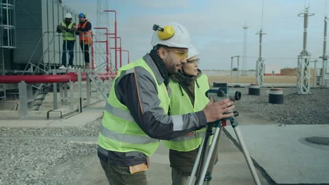 A team of construction workers at the substation next to the total station Stock Footage 145061814