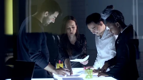 A team of creative businessmen of different races works at night in the office Stock Footage 124902123