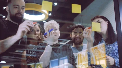 A team of creative businessmen draws a graph of business development on glass Stock Footage 108885517