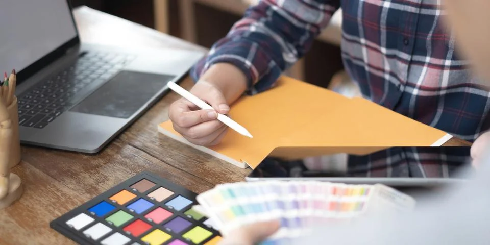Team of creative graphic designer working on color swatch samples chart for Stock Photos