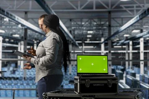 Team of data center admins using green screen notebook Stock Photos