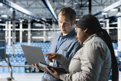 Team of data center admins using laptop to manage software updates Foto stock