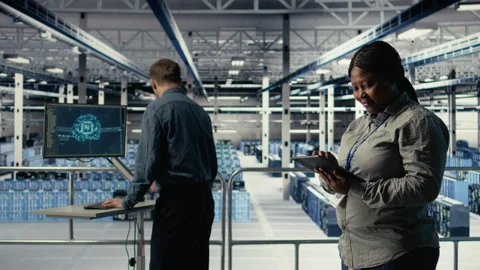 Team of data center technicians checks AI dashboard using laptop Stock Footage 314805685