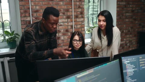 Team of designers or IT-specialists discussing in office, black man and two Stock Footage 233725710