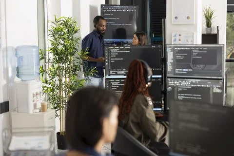 Team of developers conducts code review in open office workspace Stockfoto's