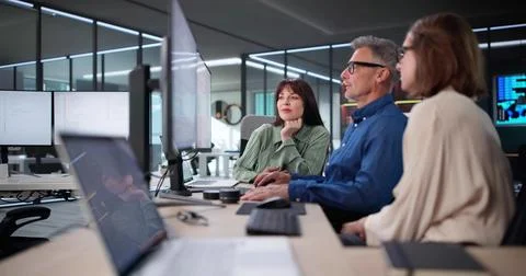 Team Of Developers Meeting In Office, Coding On Computer Monitors. 스톡 사진