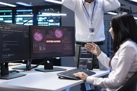 Team of developers in server hub frightened by hacker passing firewall Stock Photos