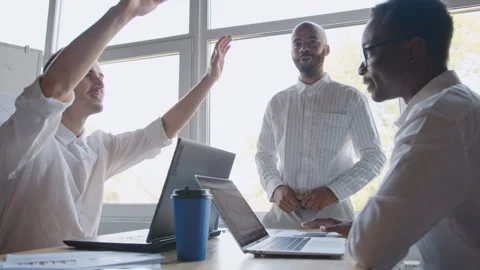 Team discusses crypto trading strategy in a bright office with laptops and Stock Footage 335731706
