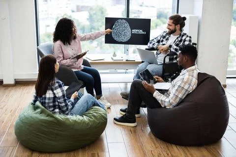 Team discussing artificial intelligence project in modern creative office space Stock Photos
