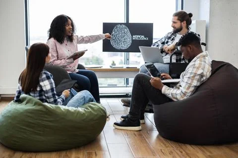 Team Discussing Artificial Intelligence Project in Modern Casual Office Setting Stock Photos