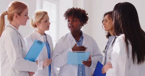 Team of diverse female doctors discussing medical case, collaborating on patient Stock Footage 312640652
