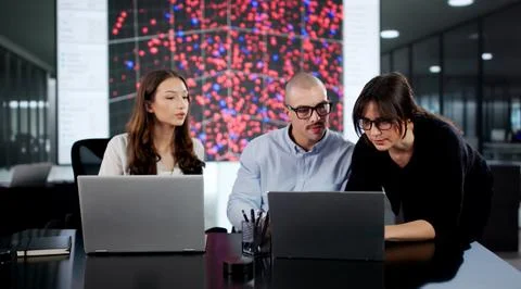 Team Of Diverse Software Engineers Securing Server Control In Office. Stock Photos