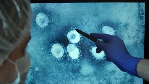 Team of doctors analyzes image of virus several times enlarged. Coronovirus Stock Footage 126993888