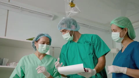 Team of doctors and nurses in the operating room are consulting Stock Footage 171403269