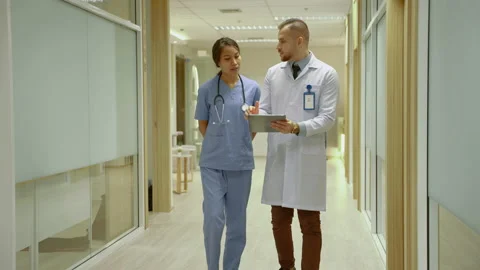 Team of doctors are walking and discussing in the corridors of the hospital. Stock Footage 224711142