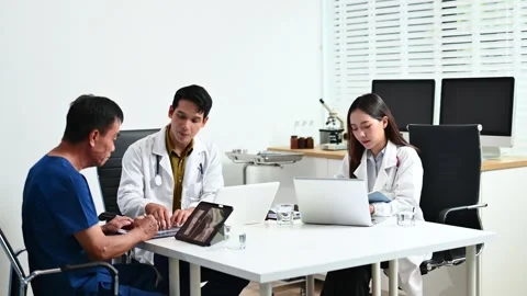 Team doctors consult a patient using laptop and tablet showing X-ray. Healt.. Stock Footage 312665849