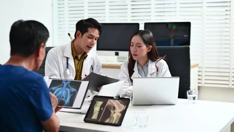 Team doctors consult a patient using laptop and tablet showing X-ray. Healt.. Stock-Footage 312665860