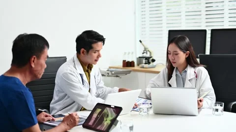 Team doctors consult a patient using laptop and tablet showing X-ray. Healt.. Stock-Footage 312665862