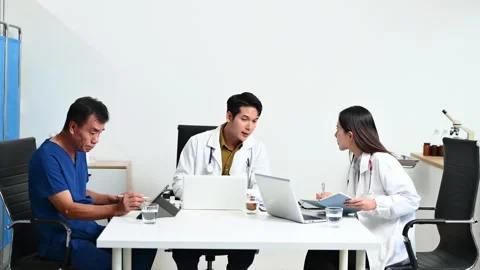 Team doctors consult a patient using laptop and tablet showing X-ray. Healt.. Stock Footage 313857870