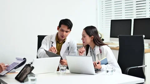 Team doctors consult a patient using laptop and tablet showing X-ray. Healt.. Video stock 313857872