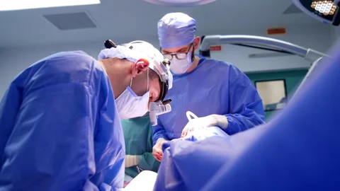 Team of doctors gathered around the operating table. Group of neurosurgeons Video stock 333337100