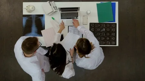 Team of doctors looking at laptop and analyzing xray in medical office 스톡 동영상 71621156