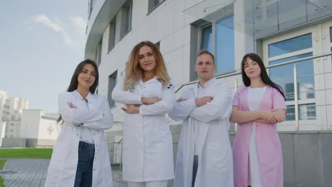 Team of doctors poses outside against the background of the hospital building Stock Footage 238736381