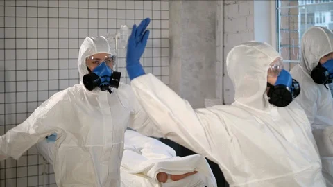 Team of doctors in protective clothes dancing in front of the isolated patient Stock-Footage 127204480