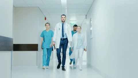 Team of Doctors, Surgeons and Nurses Walk Through Busy Hospital Hallway Stock Footage 91116744