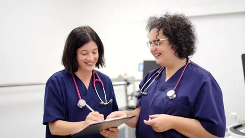 Team of doctors talking and later smiling at camera Vídeo Stock 257719119