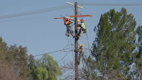 Team of electricians installing cable on electric pole Stock Footage 233657773