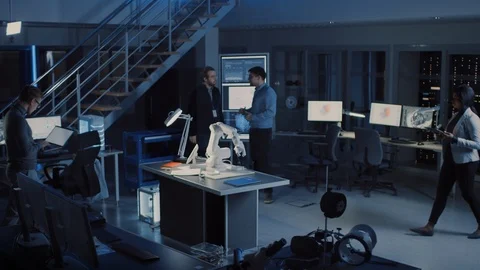 Team of Electronics Development Engineers Standing at Desk Working on Robot Arm Stock Footage 104598567