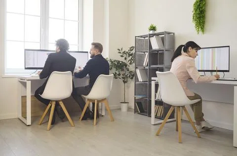 Team of employees working at computers in open office, analyzing data charts Stock Photos