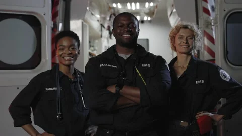 Team of ems paramedics in uniform posing near ambulance Video stock 164029900