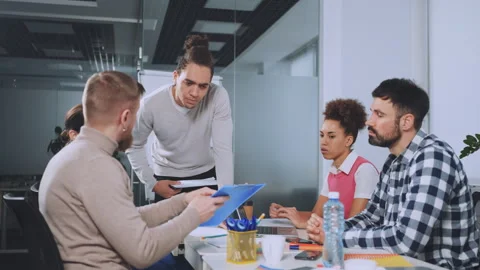 Team Engaged in Office Discussion with Documents Stock Footage 278733564