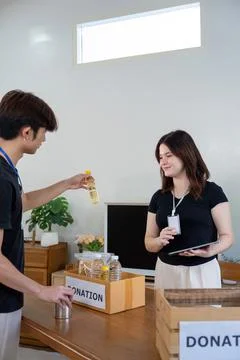 Team Engaging in Donation Sorting for Outreach Program Stock Photos