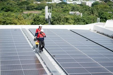 Team engineer and technician working on solar panel installation at rooftop.. Stock Photos
