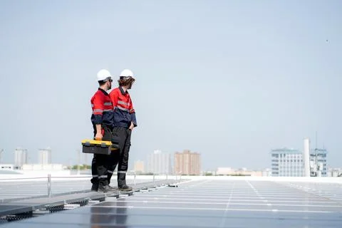 Team engineer and technician working on solar panel installation at rooftop.. Stock Photos