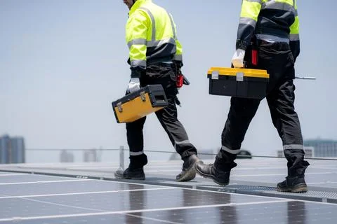 Team engineer and technician working on solar panel installation at rooftop.. Stock Photos