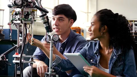 Team engineer collaborating on develop of robot in workshop. Stock Footage 94279490