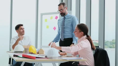 A team of engineers and architects meets at Brainstrom to work and discuss pr Stock Footage 153661657