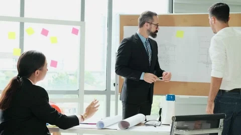 A team of engineers and architects meets at Brainstorm to work and discuss pr Stock Footage 153669095